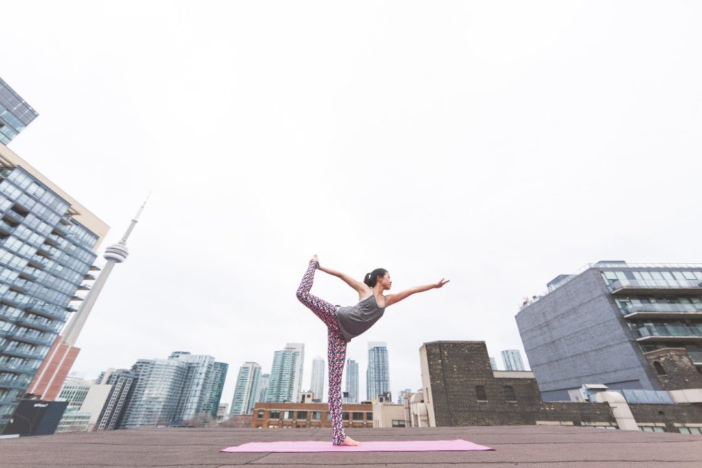 Person doing a yoga pose with a city landscape