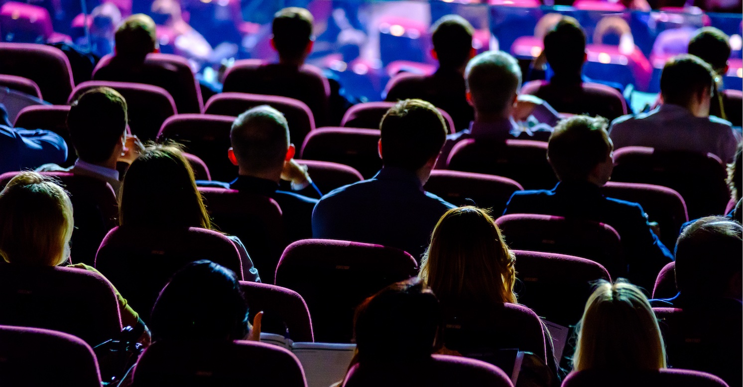 A seated audience watching a speech